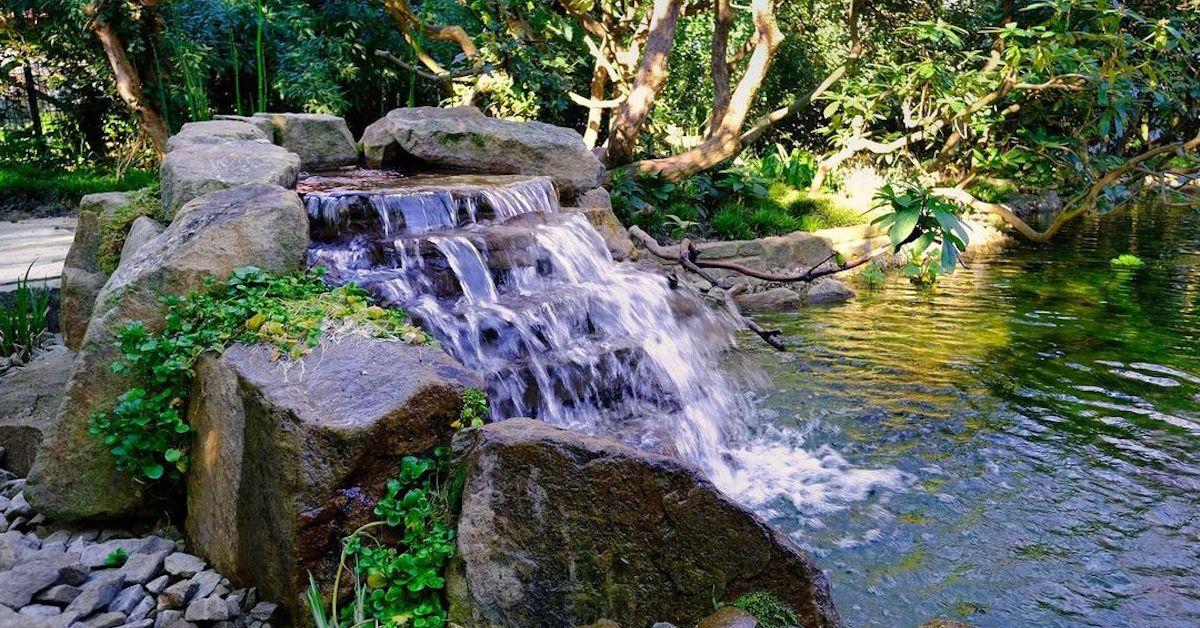 A rocky waterfall by a pond