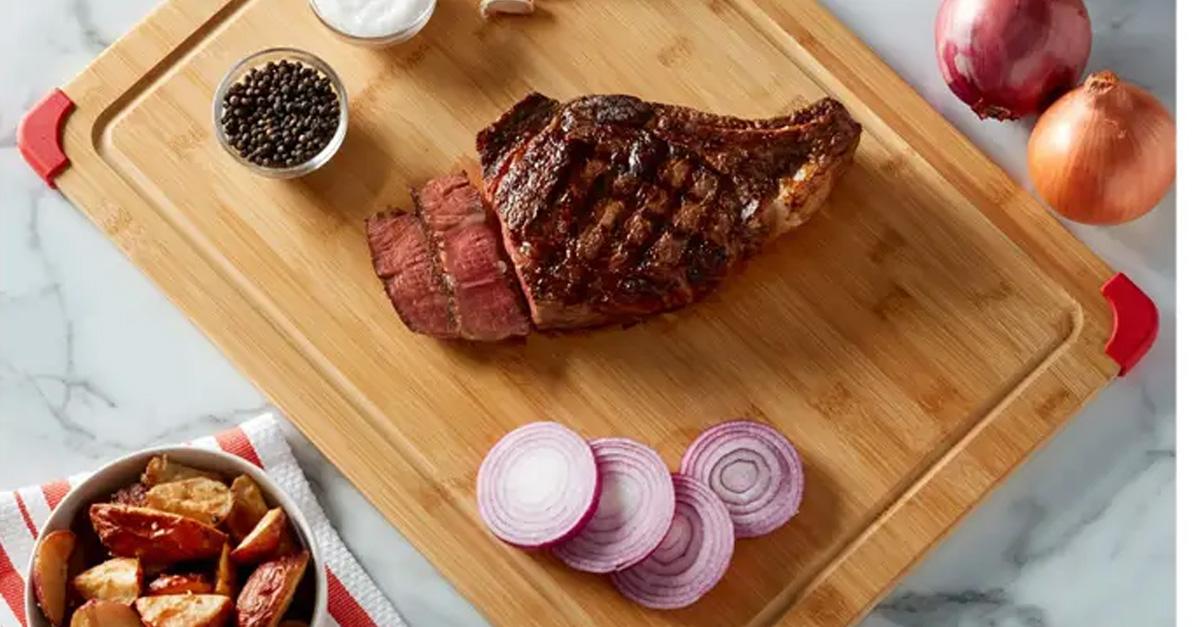 Bamboo cutting board with sliced meat and vegetables