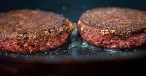 Two plant-based Beyond Burgers on a grill