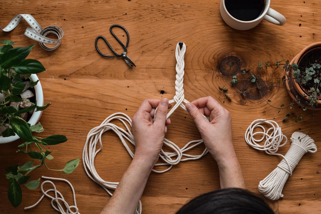 Overhead view of someone working with cords for a macrame project.