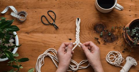 Overhead view of someone working with cords for a macrame project.