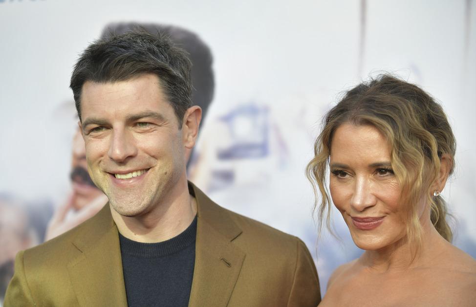 Max Greenfield and Tess Sanchez smile on a red carpet.