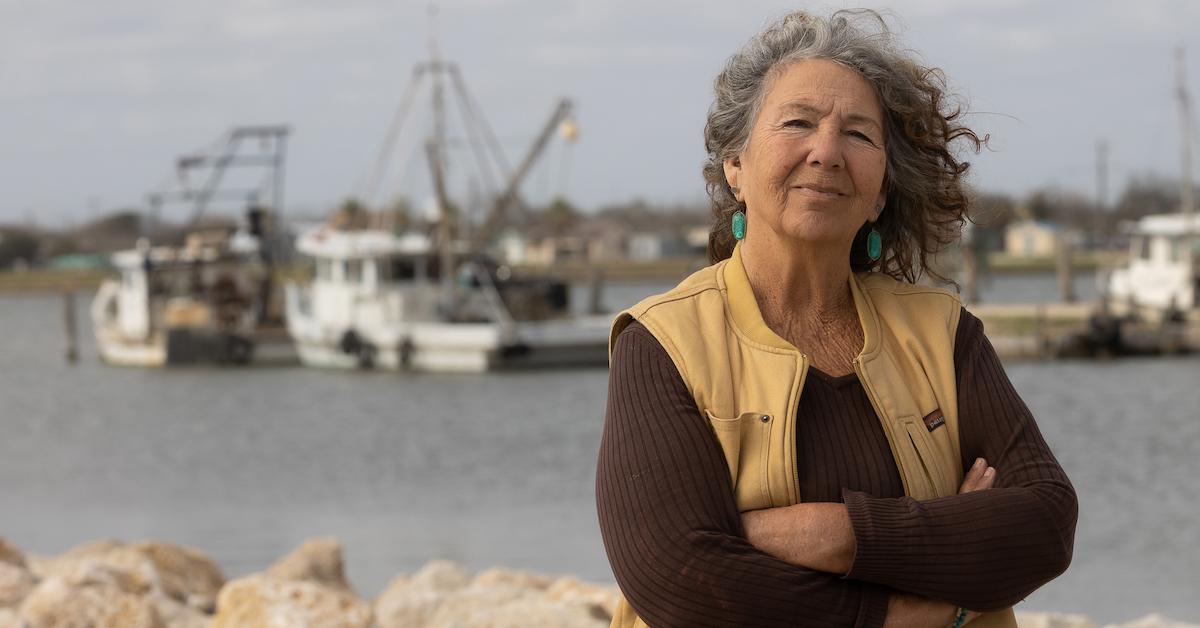 Diane Wilson with a background of ships and the ocean.