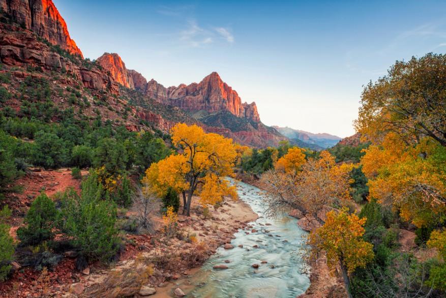 The mountains, orange and green trees, and Virgin River are pictured near Watchman Campground in Zion National Park.