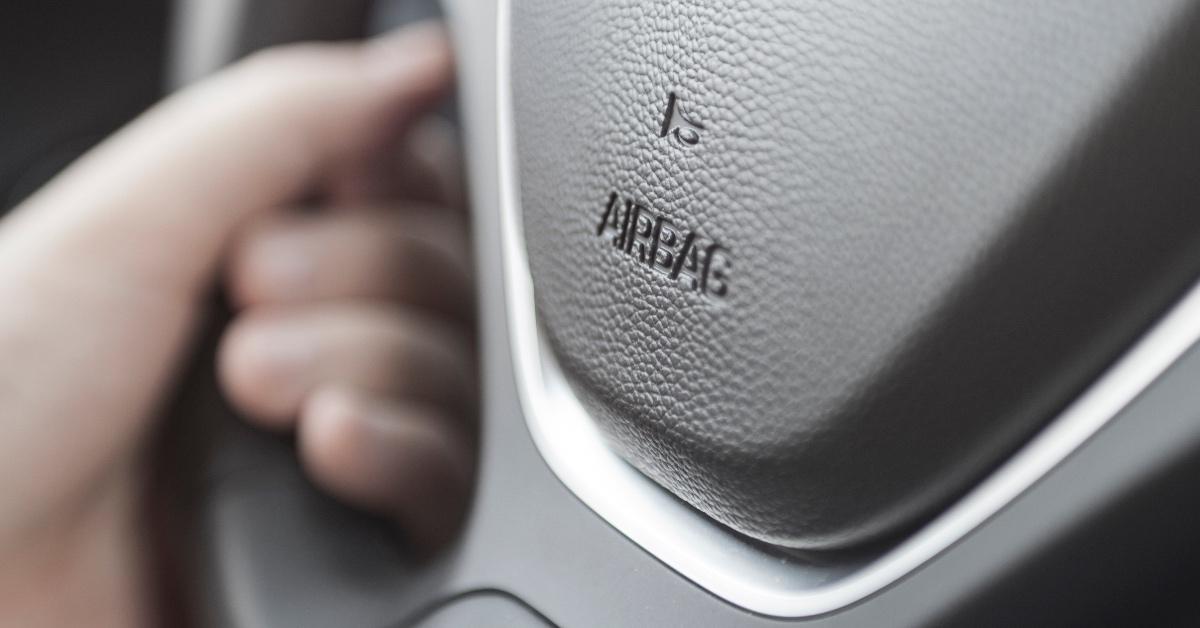 Close-up photo of an airbag button on car steering wheel.