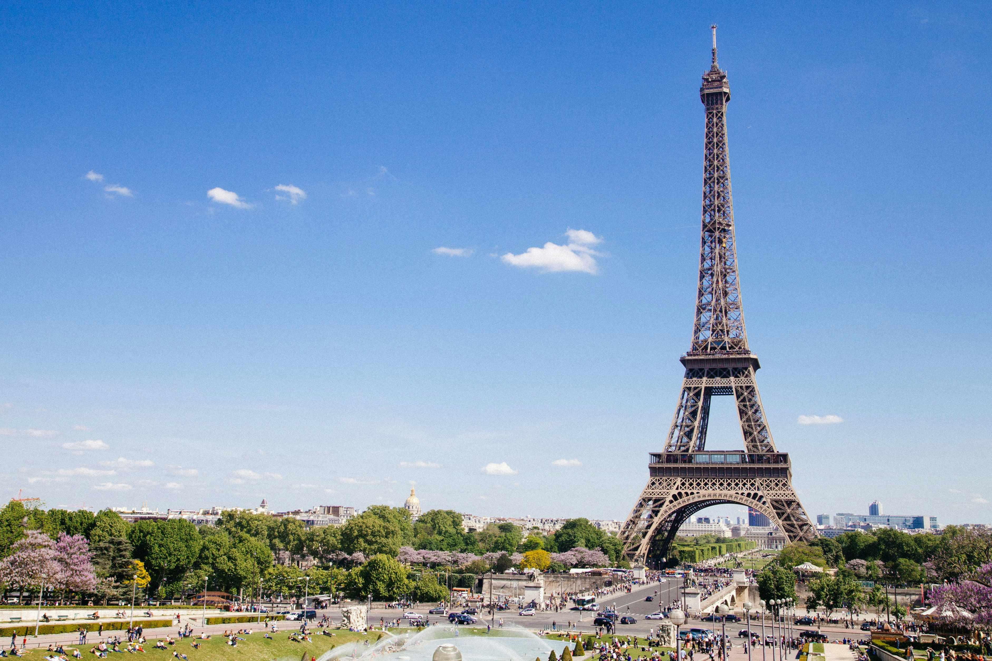 The Eiffel Tower is pictured on a sunny day with minimal clouds.