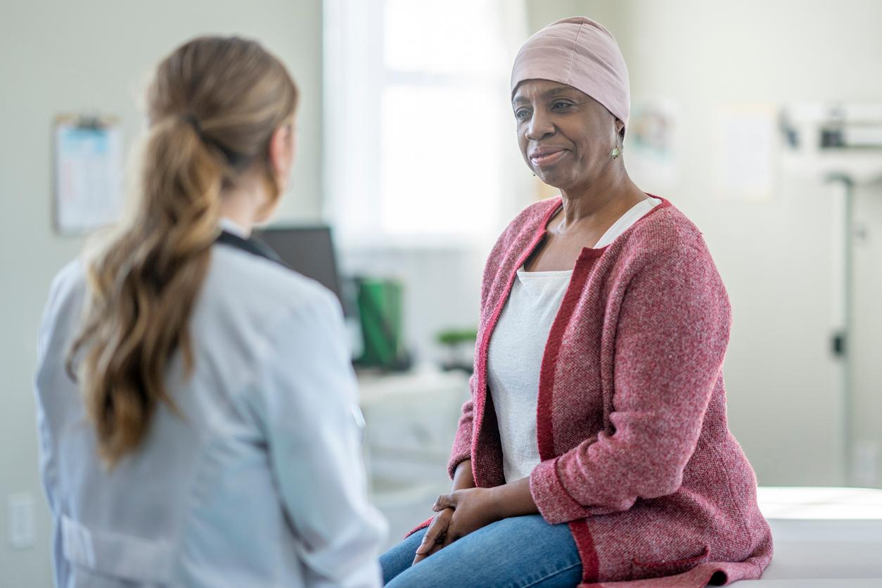 A female oncologist sits across from a black female cancer patient.