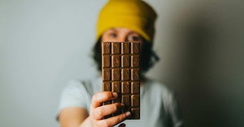 Woman displays a bar of chocolate (Representative Cover Image Source: Unsplash | Tamas Pap)