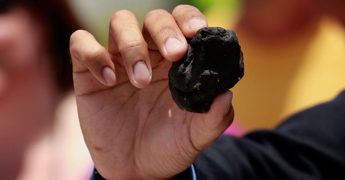 Hand holding a tar ball. 