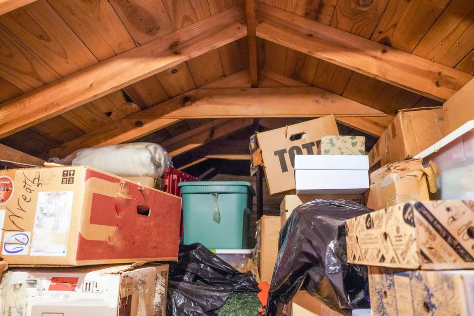 A messy attic full of boxes and storage. 