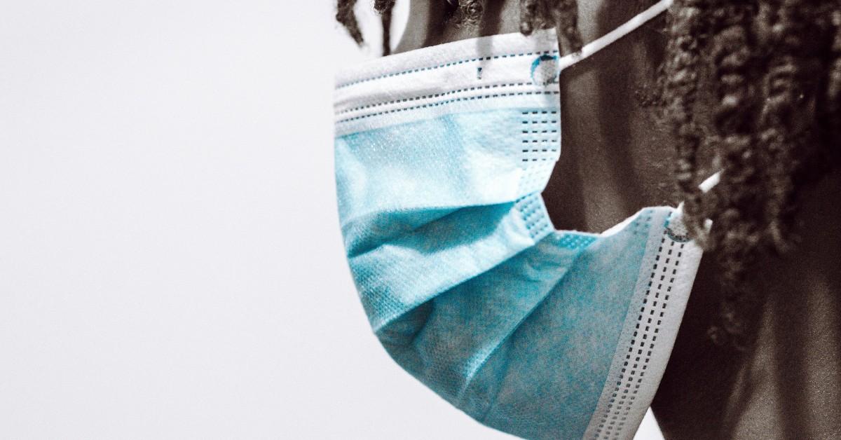 A closeup of a man in a blue face mask