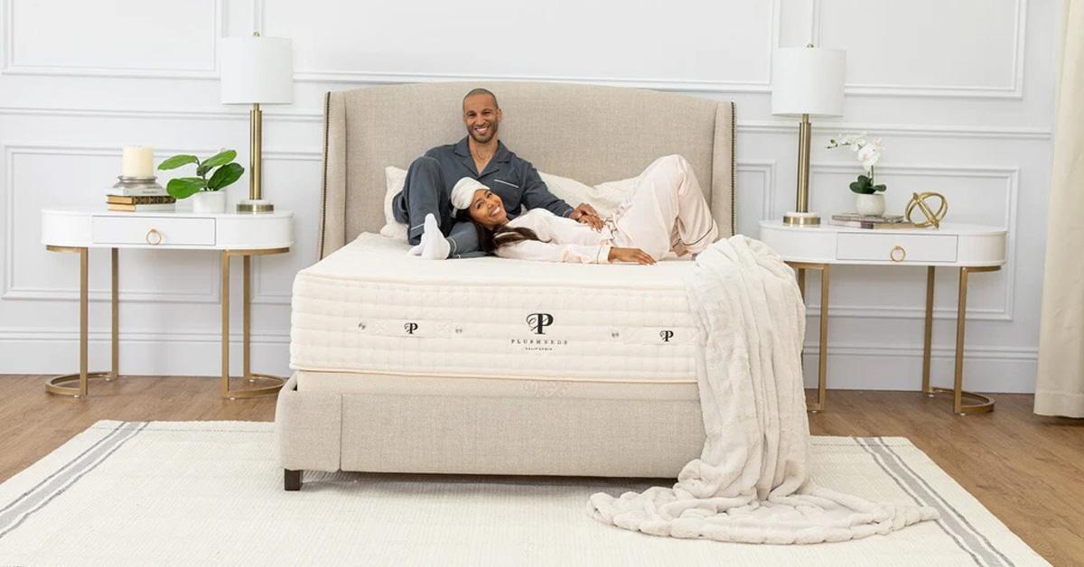 couple lying on a mattress with a blanket and rug in their bedroom