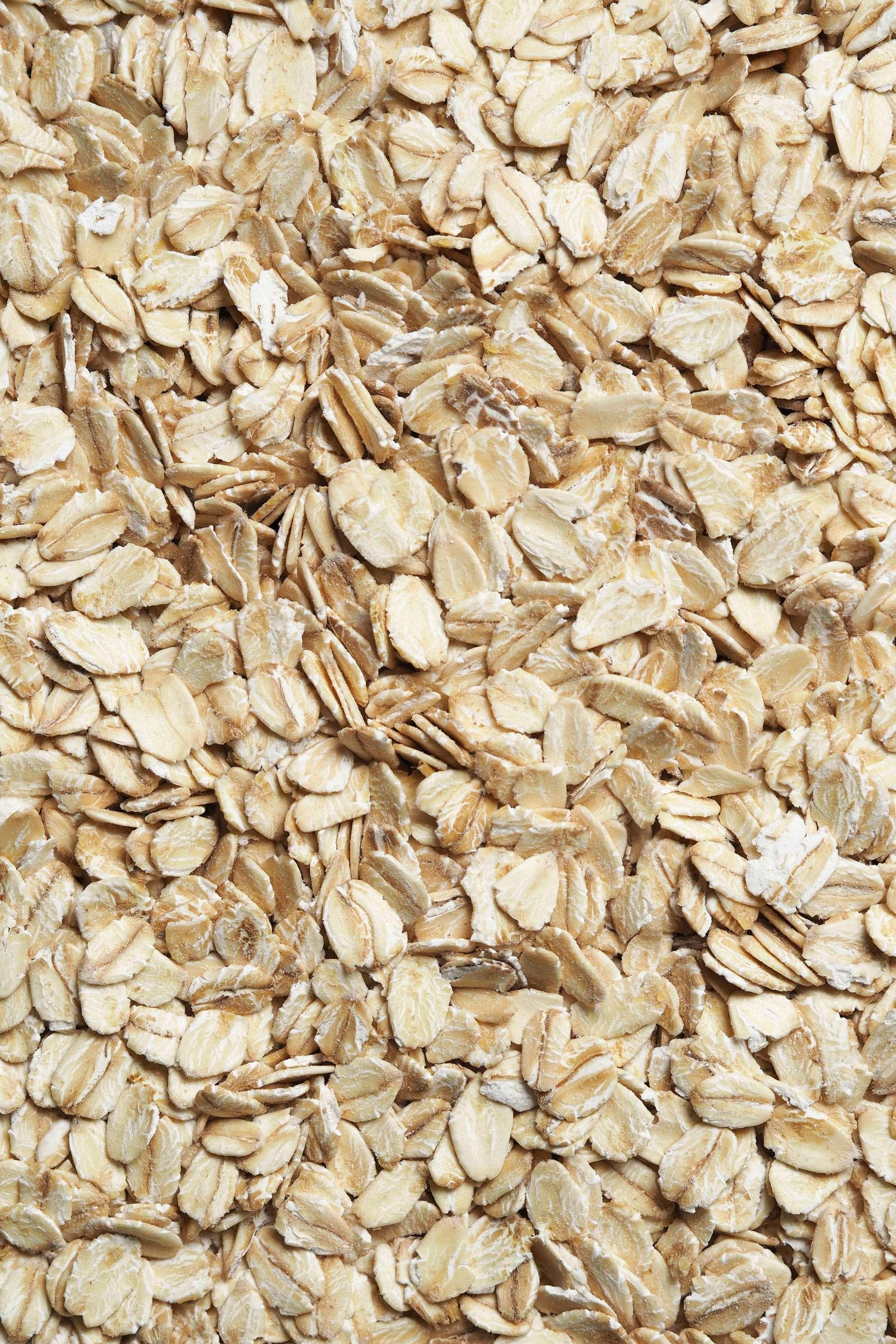 Raw, uncooked oats are pictured in a pile.