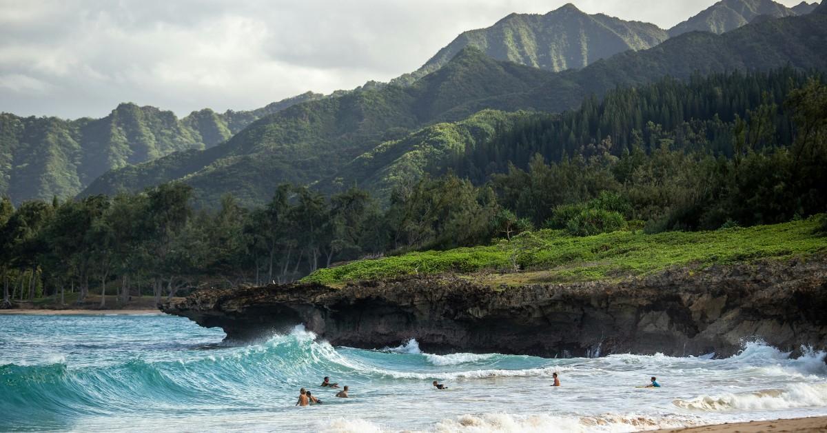 Vacationers enjoy the waves while swimming at one of Hawaii's iconic beaches