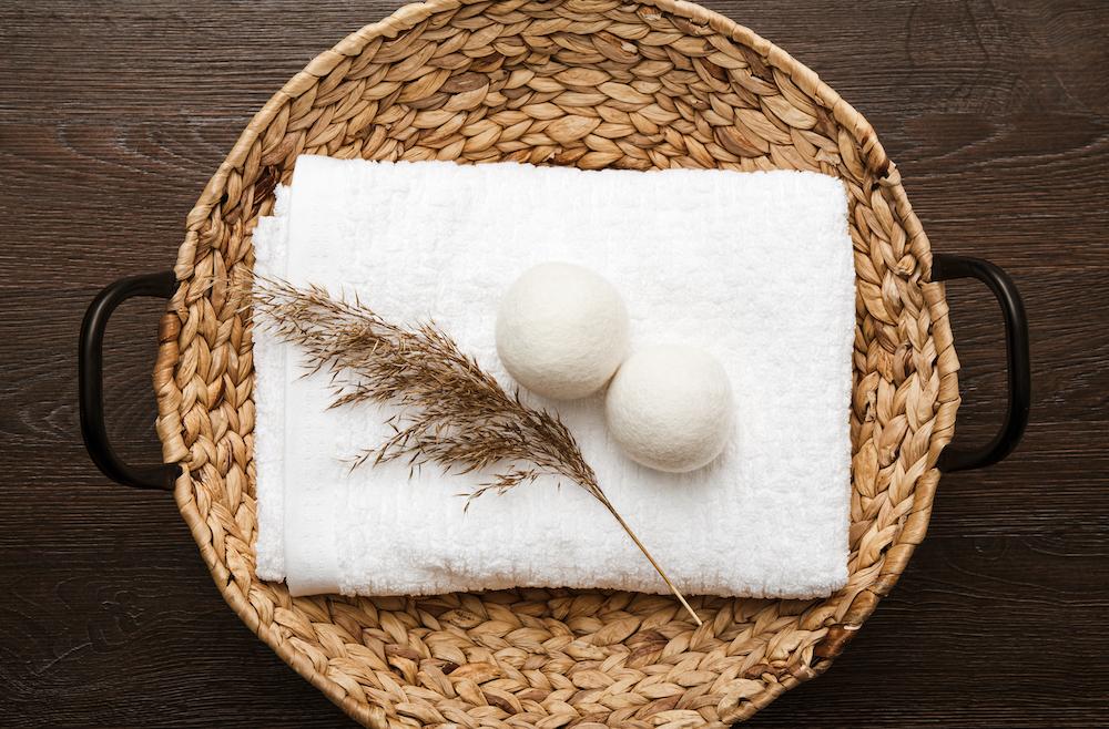 Dryer balls on top of a towel on a basket. 