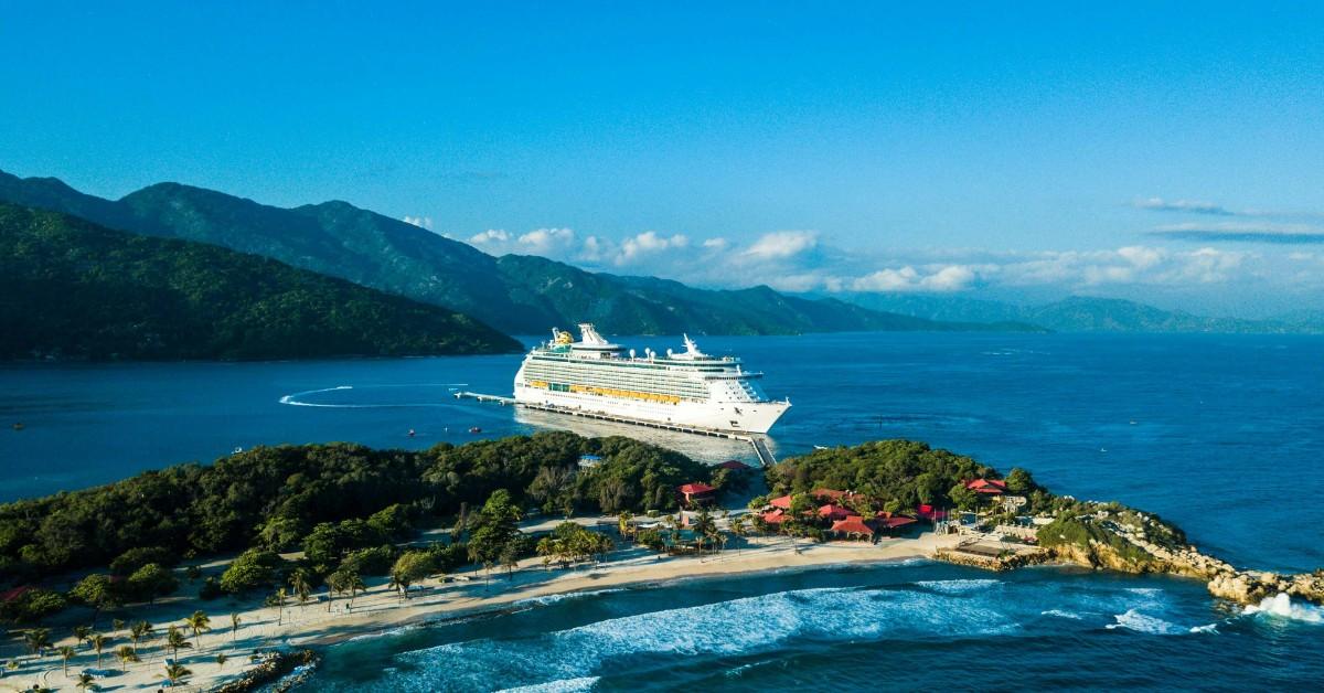 A cruise ship sits docked at a tropical location