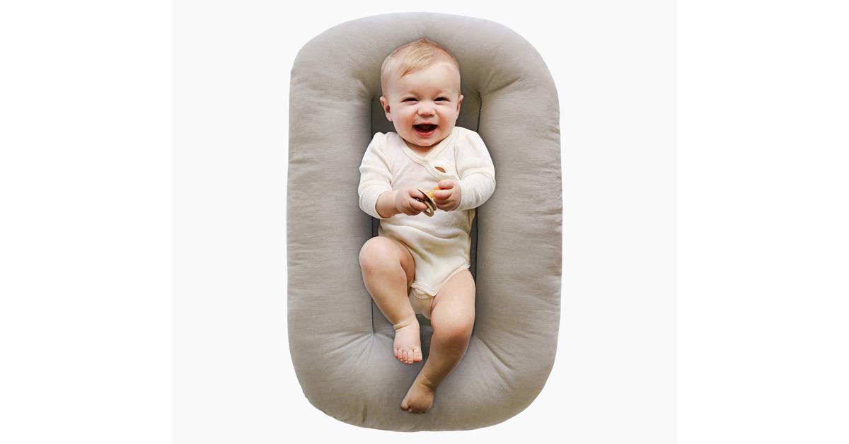 smiling baby in an oatmeal-colored baby lounger