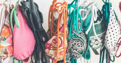 Colorful bikini tops hang from a shelf