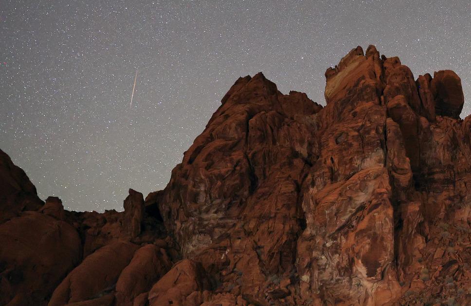 Meteor shower behind rocks