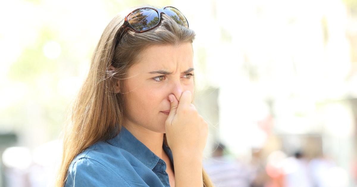 Woman putting her hand over her nose.