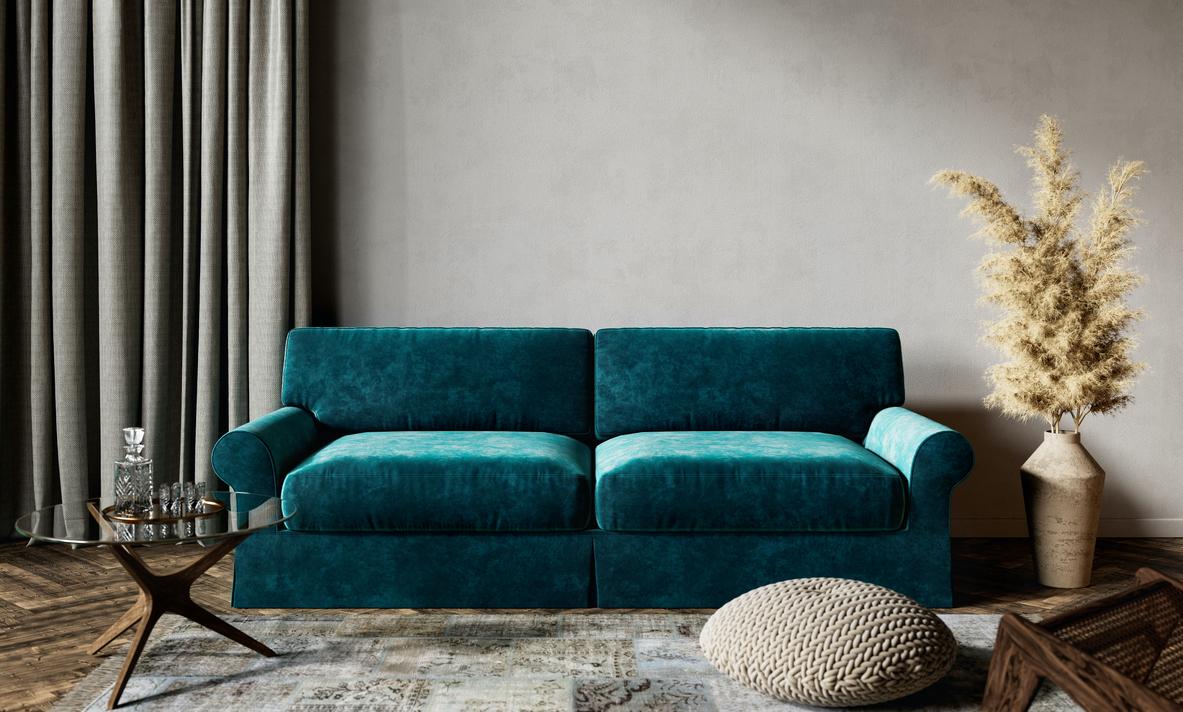 A view of a dark emerald velvet couch in a living room from a few feet away.