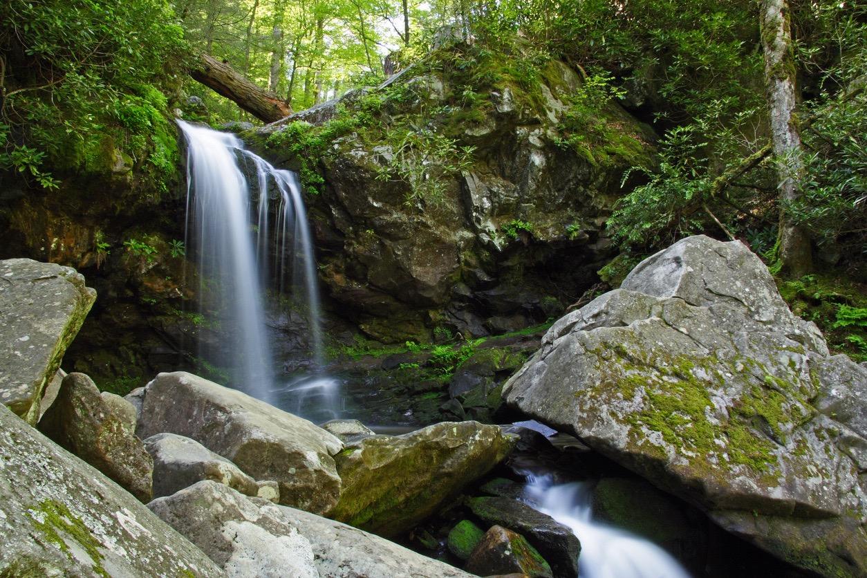 A waterfall surrounded by moss-covered rocks in the Smoky Mountains.