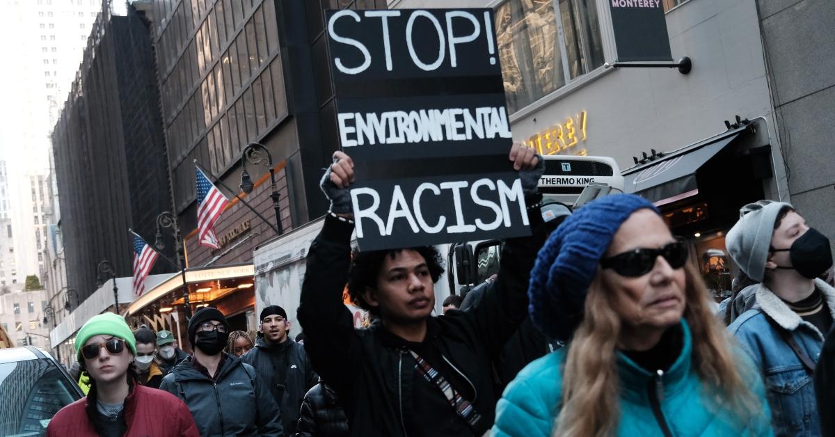 New York City activists protest Cop City on March 9, 2023, and one holds a sign reading "Stop Environmental Racism"