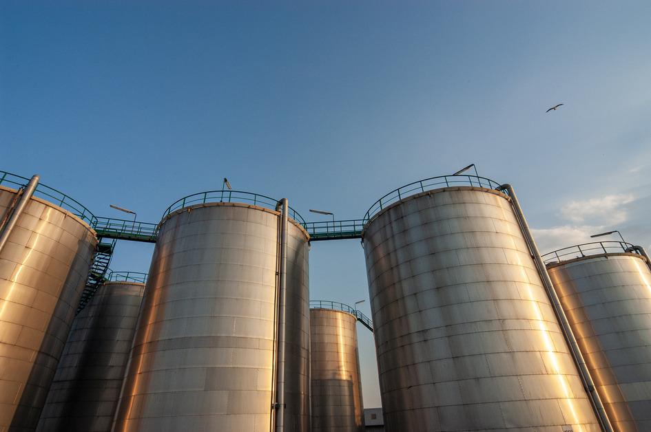 Low angle view of storage tanks taken during sunset.