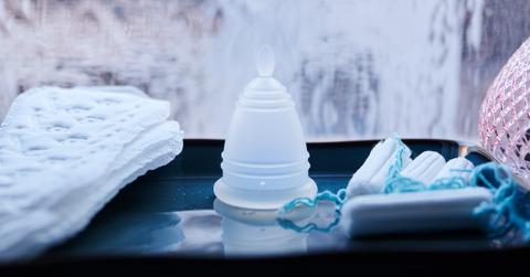 A menstrual cup, panty liners and tampons from different manufacturers are all in one bathroom.