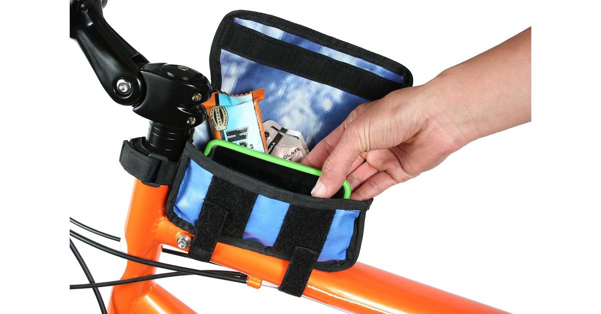 Tube bag on a bicycle while a hand reaching for a phone.