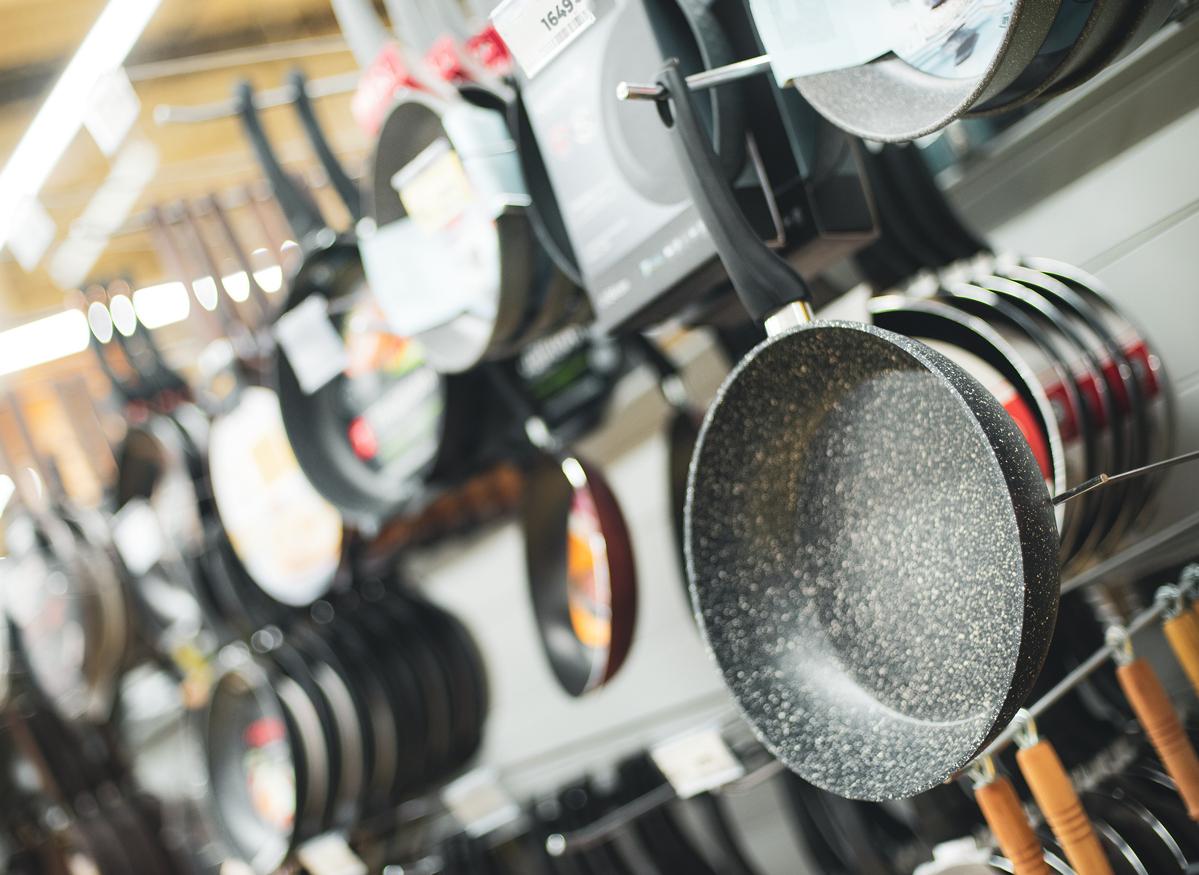 A group of Teflon-coated pans are on display for sale in a market.