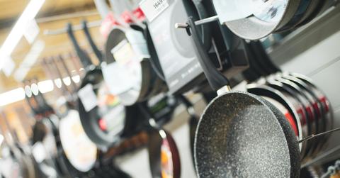 A group of Teflon-coated pans are on display for sale in a market.