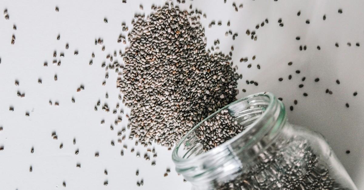 Chia seeds dumped from a glass jar into the shape of a heart