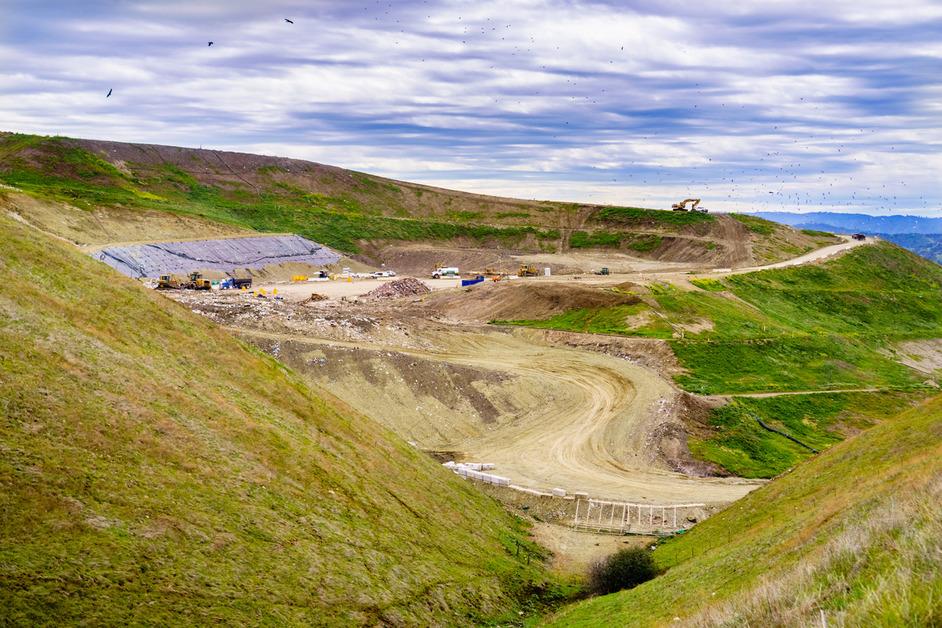 A grassy mountaintop with roads to a waste dump. 