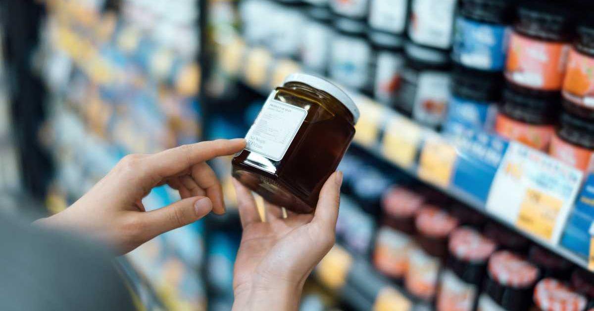 Woman purchasing a tub of red fruit jam from a supermarket shelf (Representative Cover Image Source: Getty Images | D3Sign)