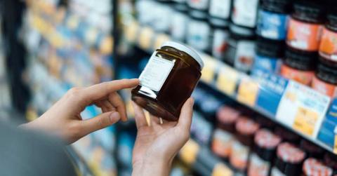 Woman purchasing a tub of red fruit jam from a supermarket shelf (Representative Cover Image Source: Getty Images | D3Sign)