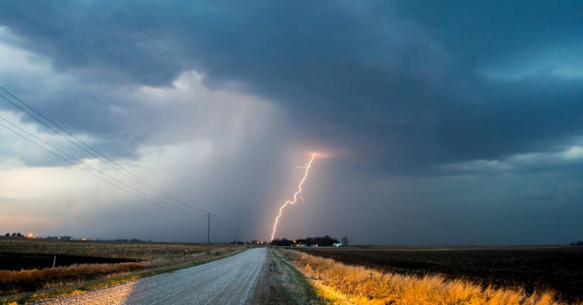 A lightning bolt strike hits the ground along the road