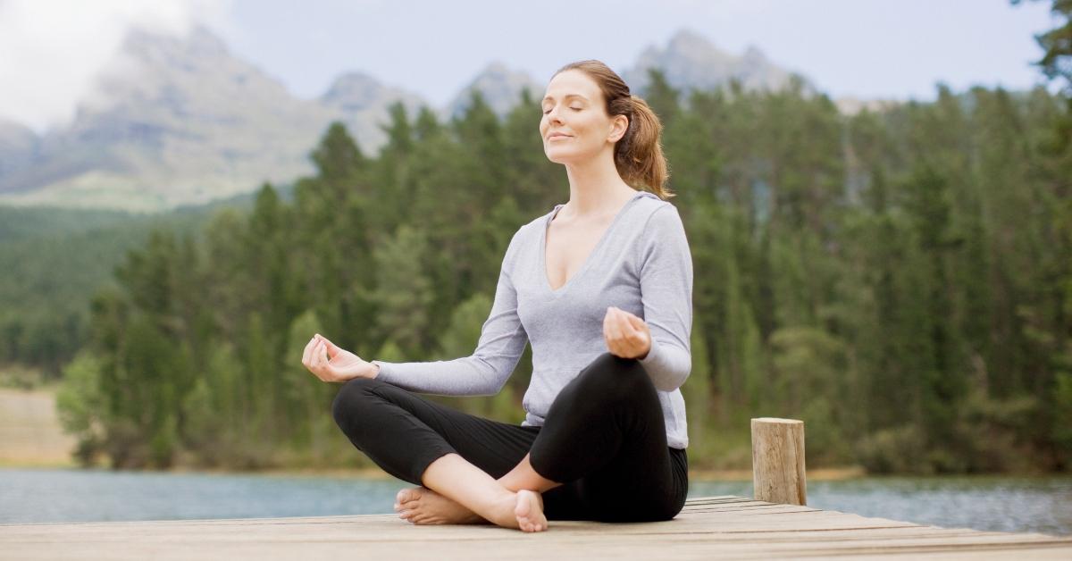 A woman meditating outside. 