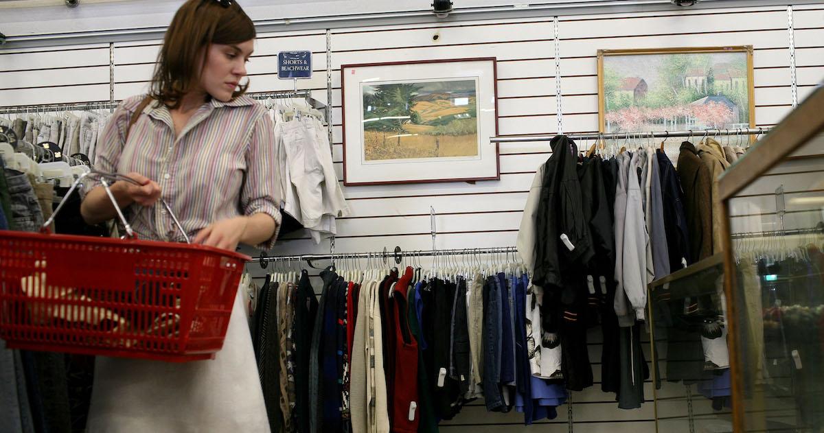 Woman holds a red shopping basket in a thrift store