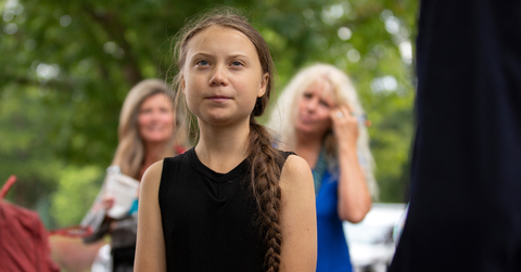 Greta Thunberg stands in a crowd