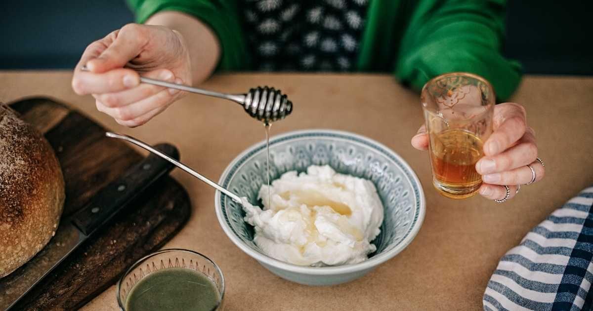 A woman adding ingredients to a bowl of yoghurt. (Representative Cover Image Source: Getty Images | knape)