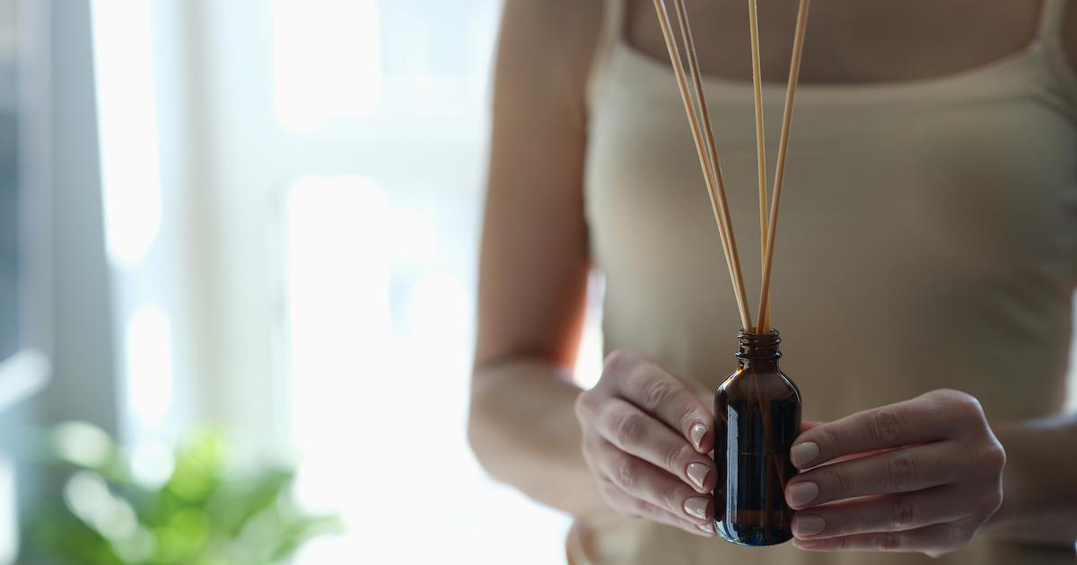 A woman holding a diffuser.