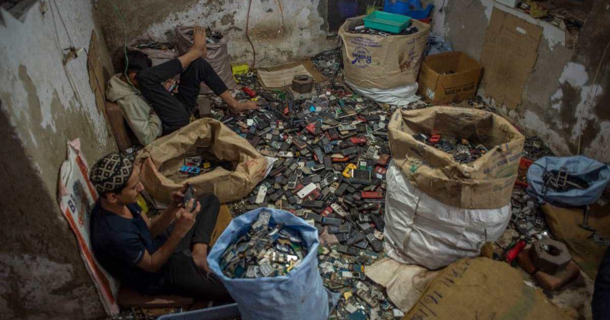 Laborers sitting with a heap of e-waste. (Representative Cover Image Source: Getty Images | Yawar Nazir)