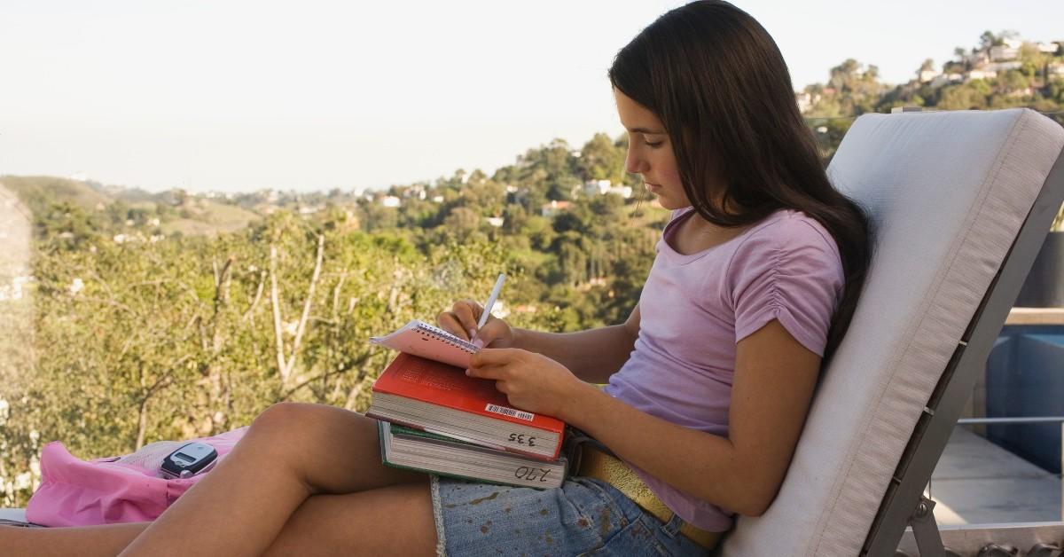 Girl writing while sitting outside