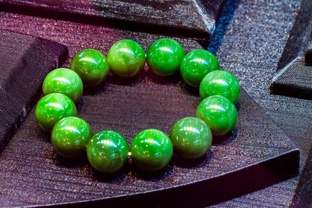 A green bracelet on a black base.