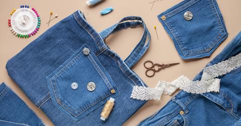 An upcycled, denim tote bag surrounded by other fabric and craft supplies.