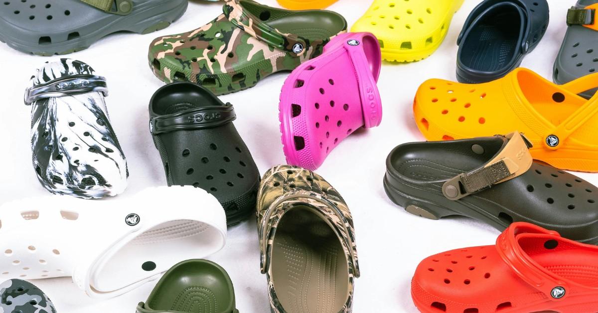 A pile of colorful crocks sits on the floor