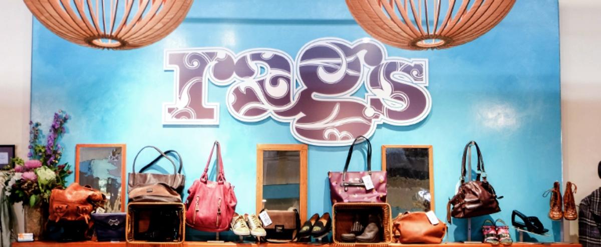 "rags" logo on wall of store with purses and shoes