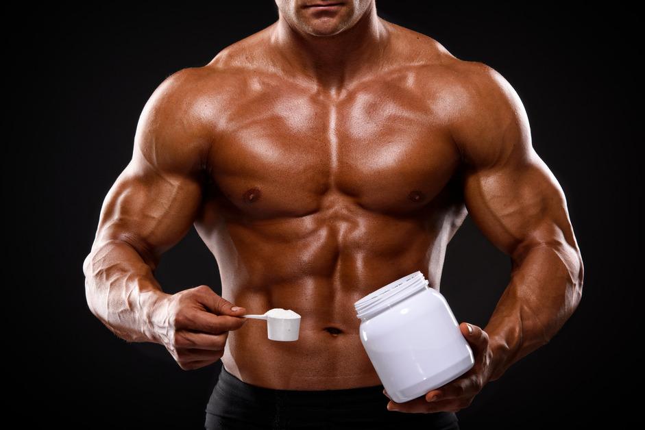 Close-up of a male athlete with a scoop of protein powder or supplement. 
