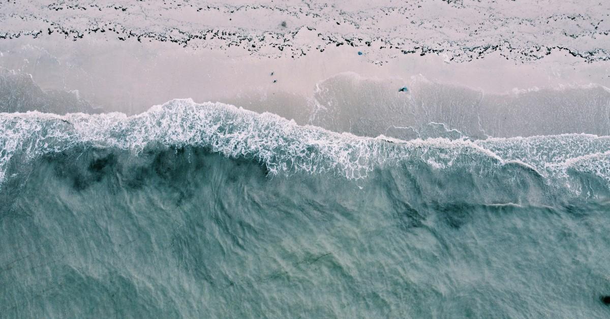 An overhead view of waves crashing on the beach